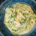Garlic butter zucchini noodles topped with parmesan cheese in a skillet